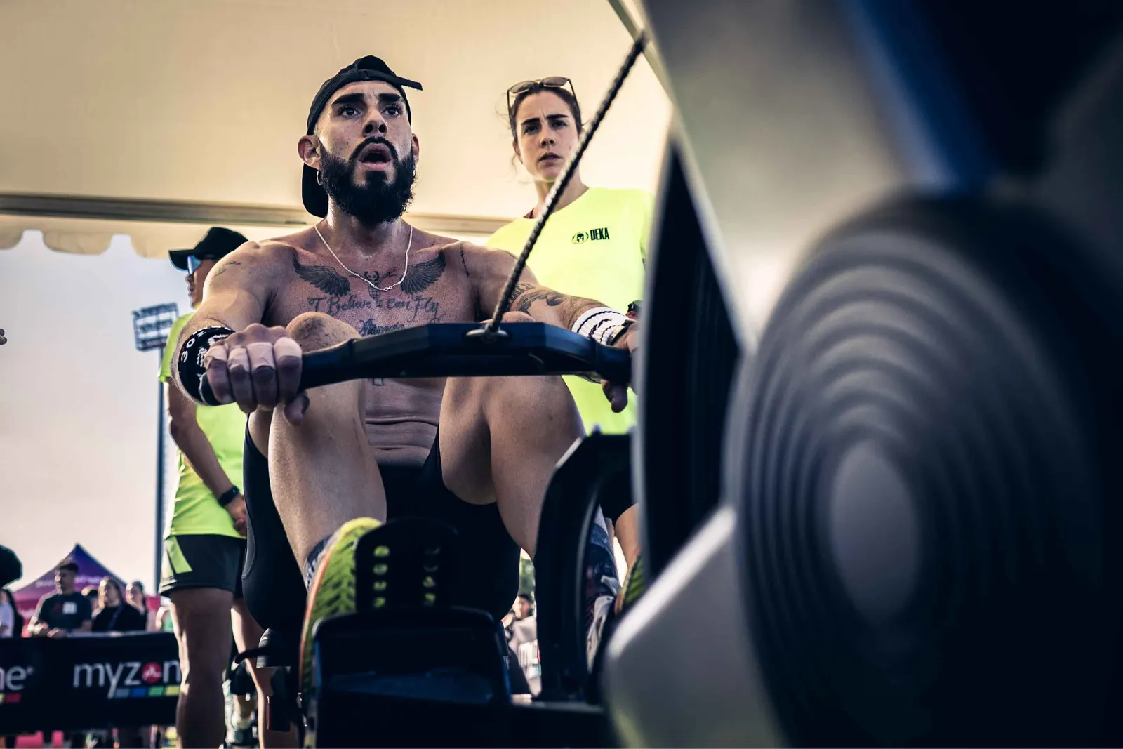 Atleta remando en un ergómetro durante una prueba DEKA en Tenerife, observado por una jueza
