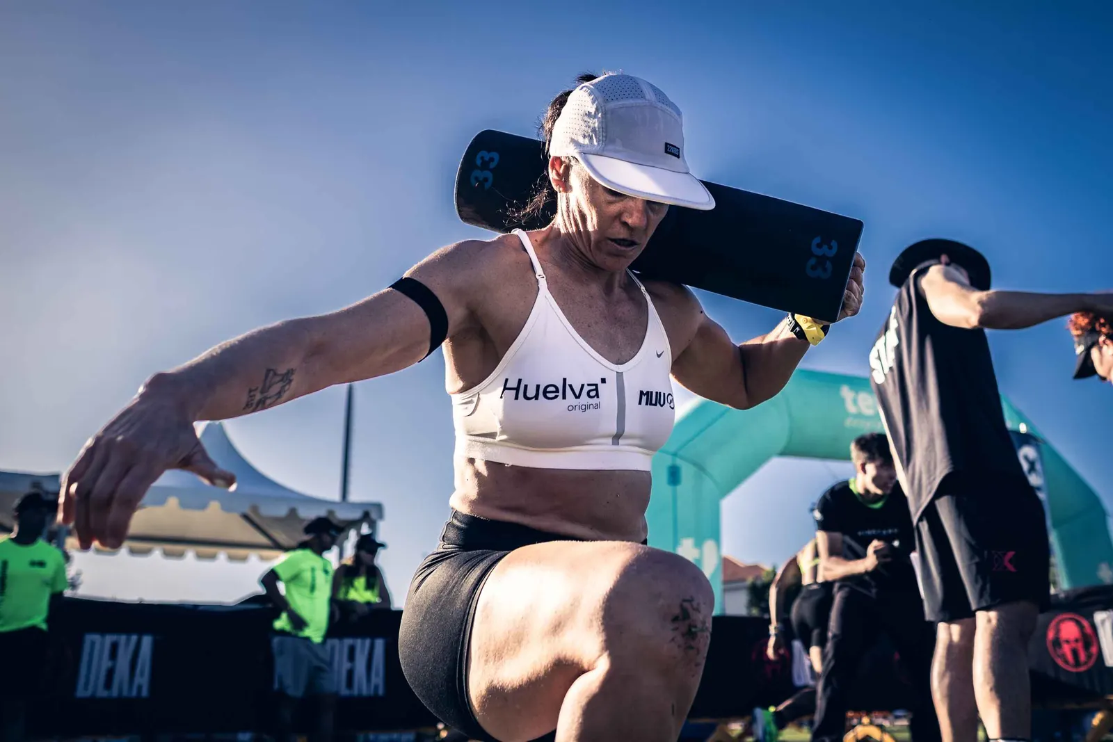 Atleta cargando un saco Project RAM bajo el cielo azul en DEKA Tenerife