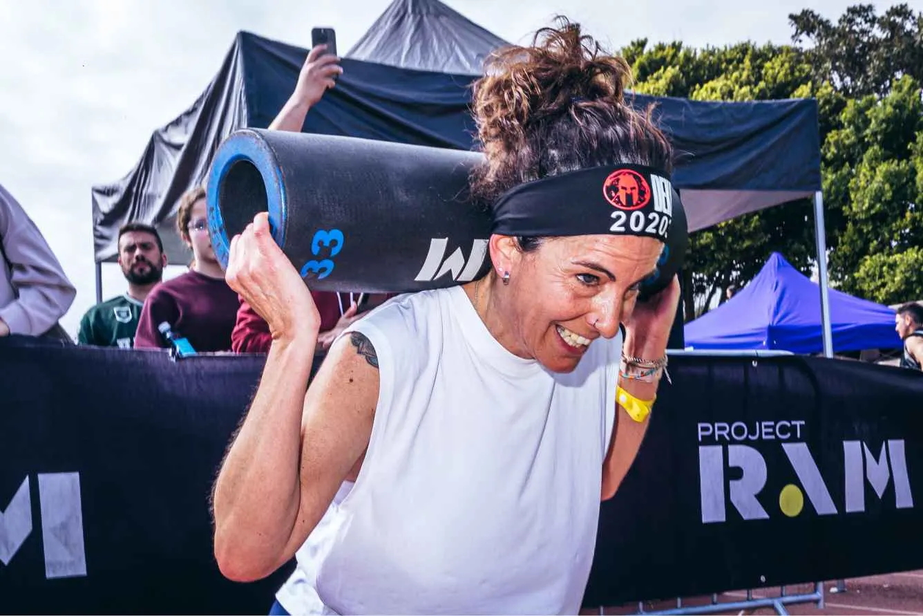 Atleta sonriendo con un saco Project RAM sobre los hombros en DEKA Torremolinos
